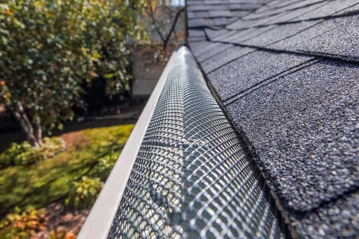 A contractor demonstrating the effectiveness of a gutter guard to a potential client in Lincoln